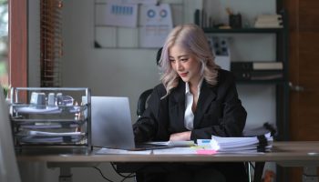 Smiling asian business woman sitting in a modern office.
