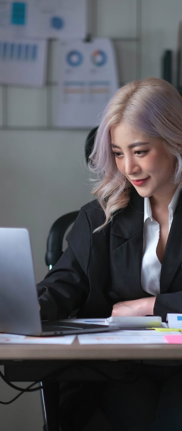 Smiling asian business woman sitting in a modern office.